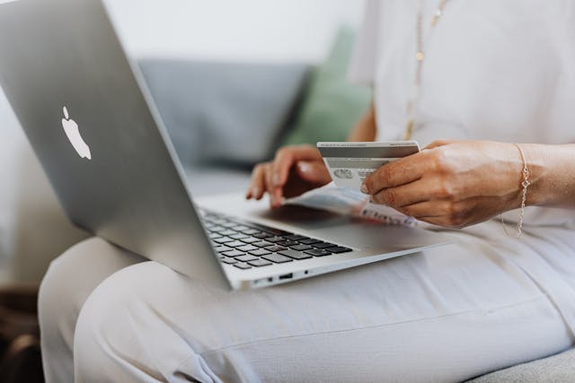 Computer sittin on tenant lap while tenat pays rent with card.