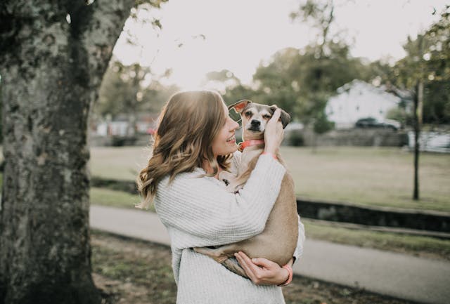 tenant holding dog in arms and smiling