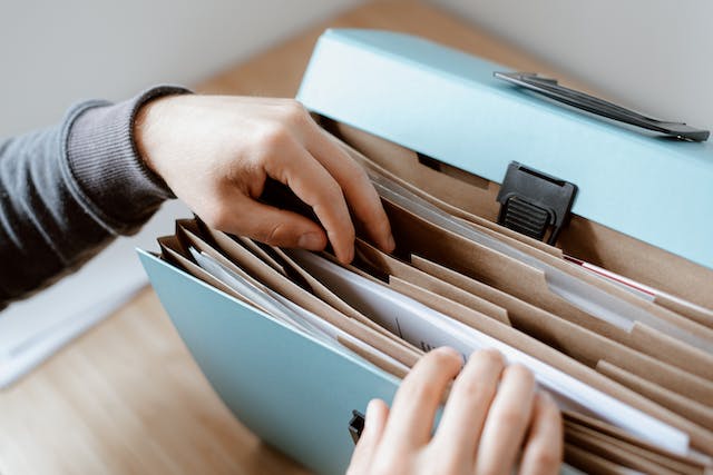 person-looking-through-a-file-folder-for-documents